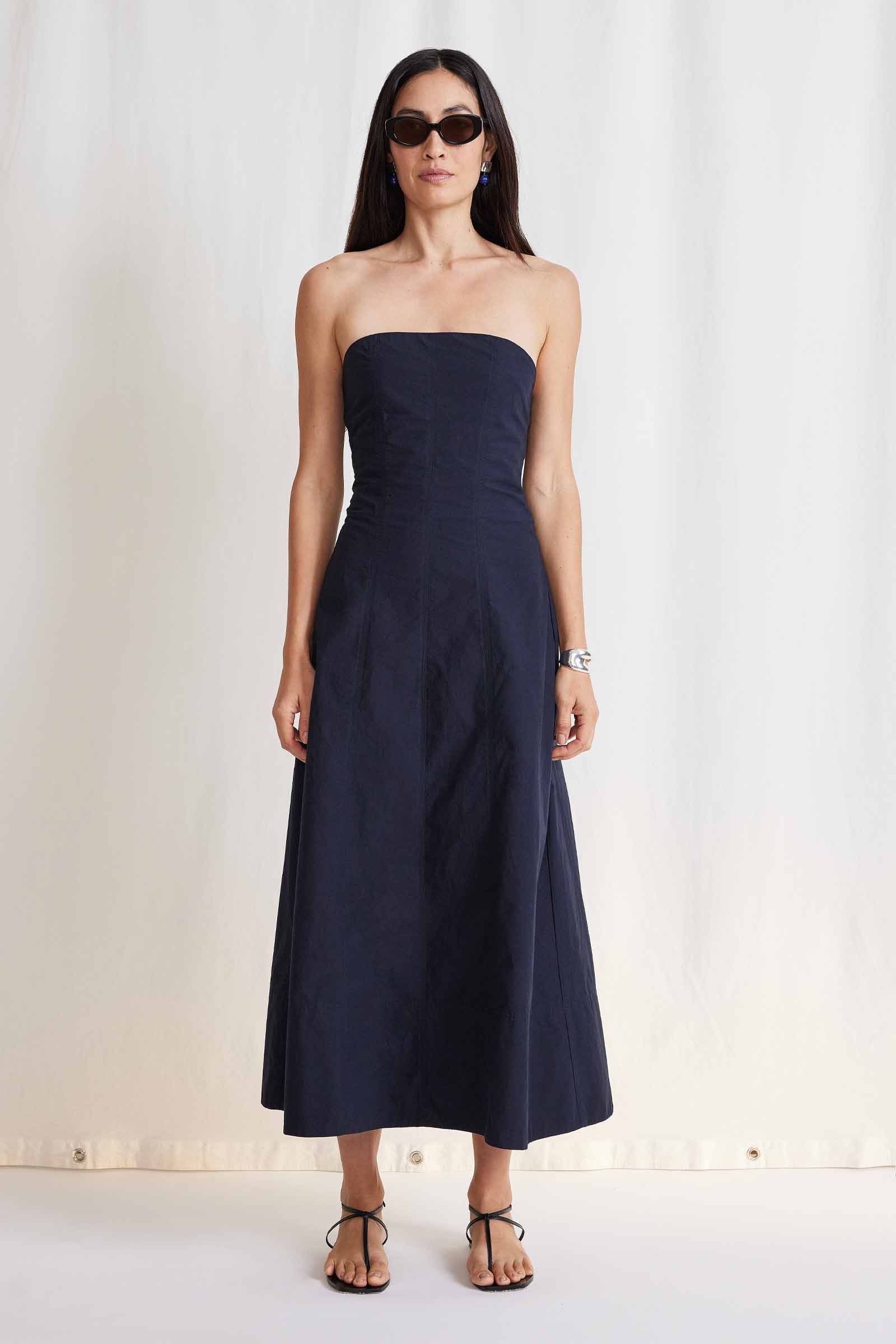 A lookbook image of a model wearing the Apiece Apart Todo Strapless Maxi Dress.