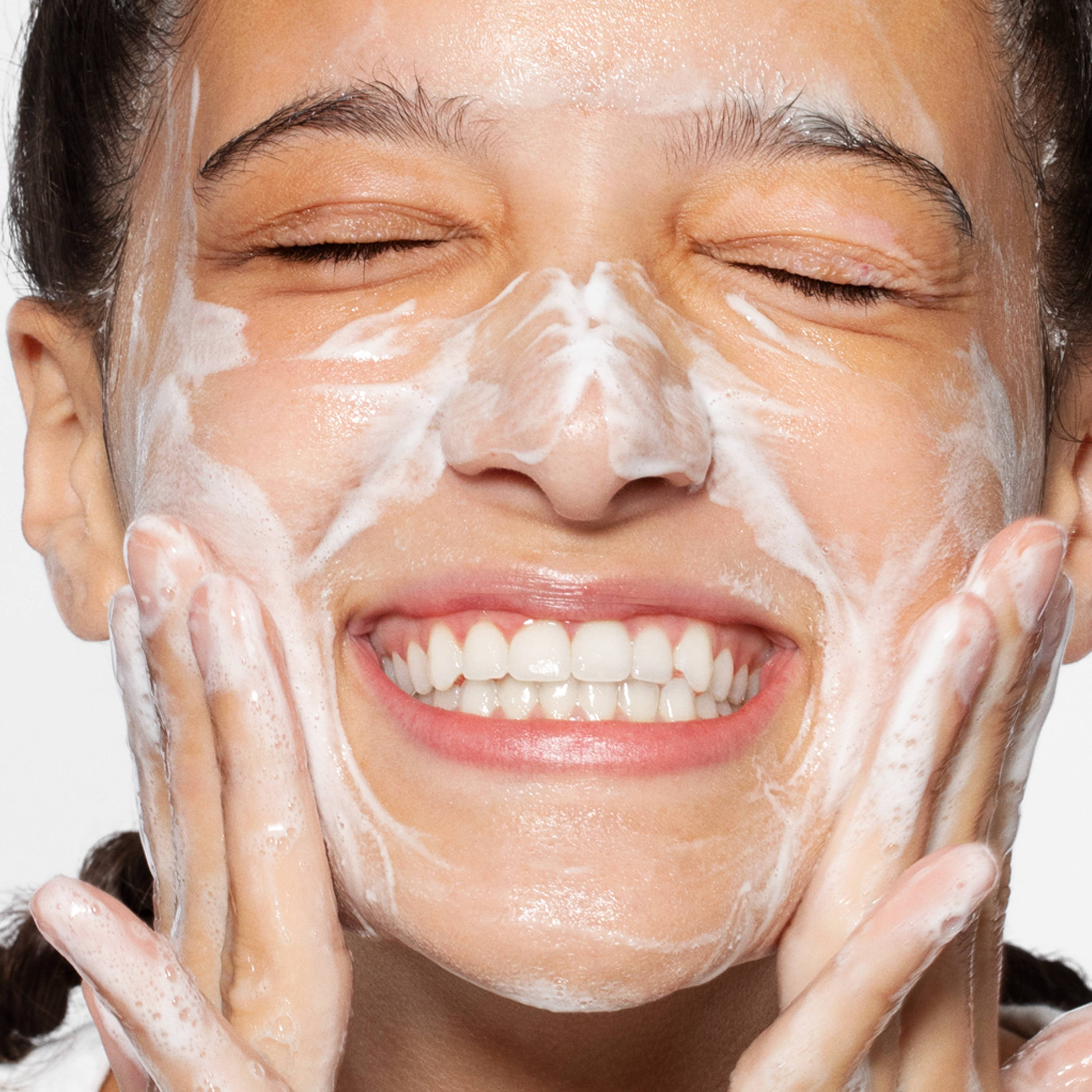 Woman cleansing face and smiling