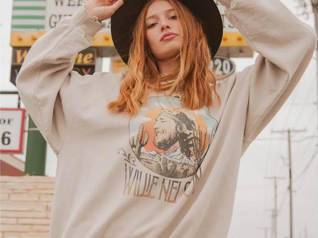 Young woman modeling a Willie Nelson graphic sweatshirt