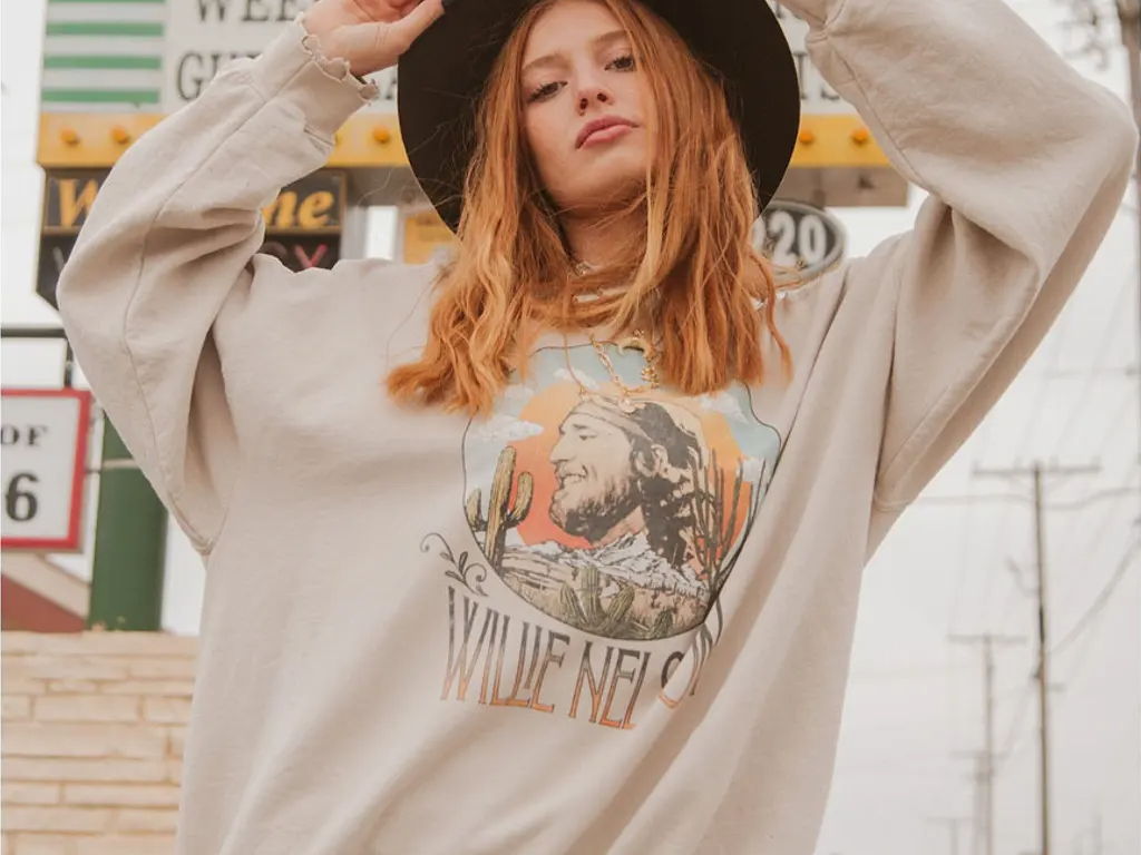 Young girl wearing large brim hat and willie nelson shirt