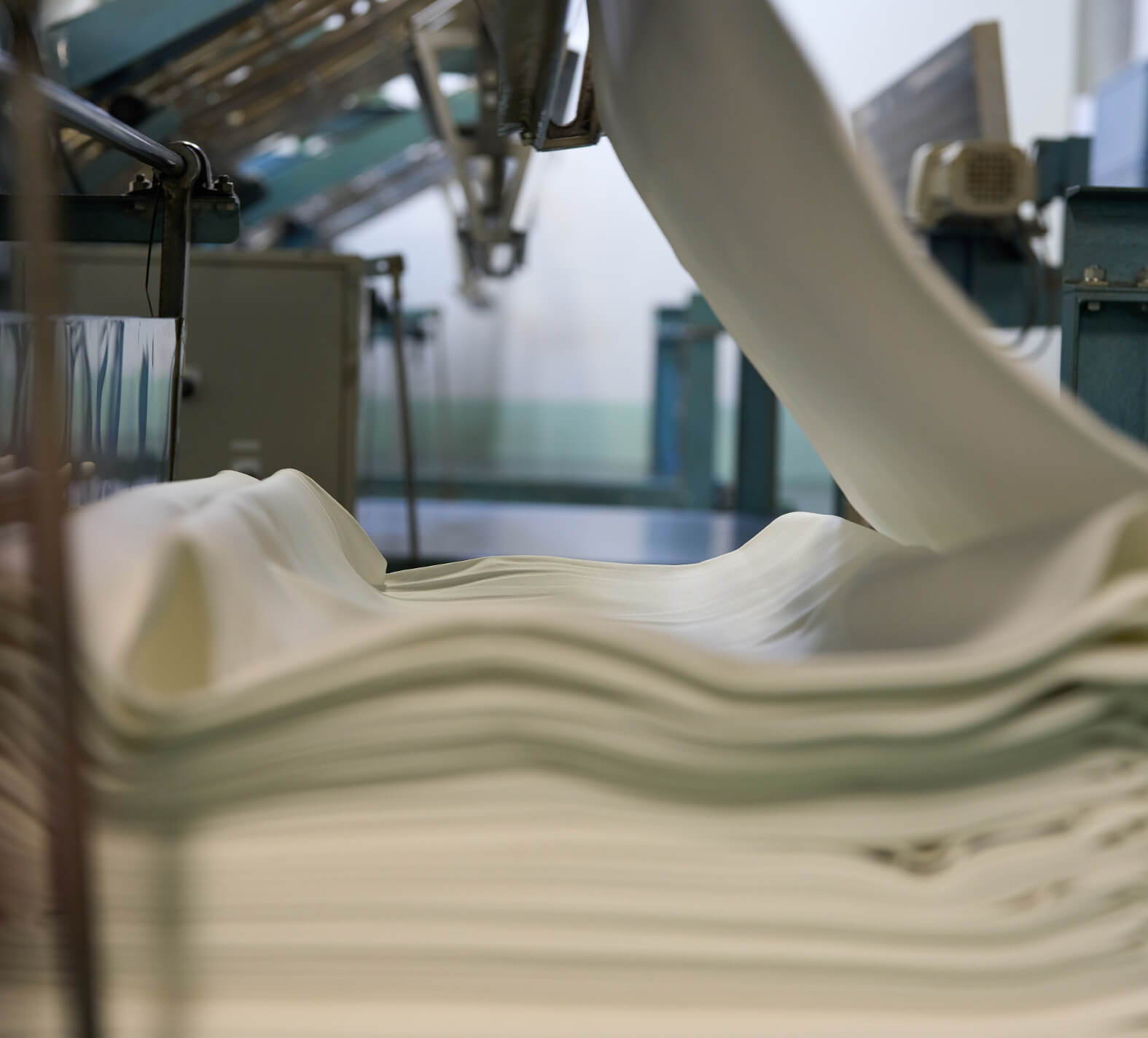 Rolls of fabric being processed in a manufacturing facility.