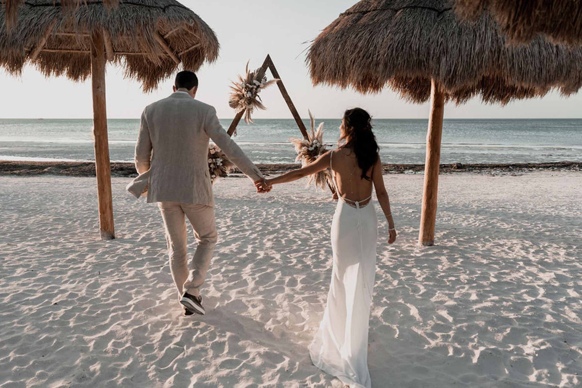 Bride and groom. holding hands on the beach
