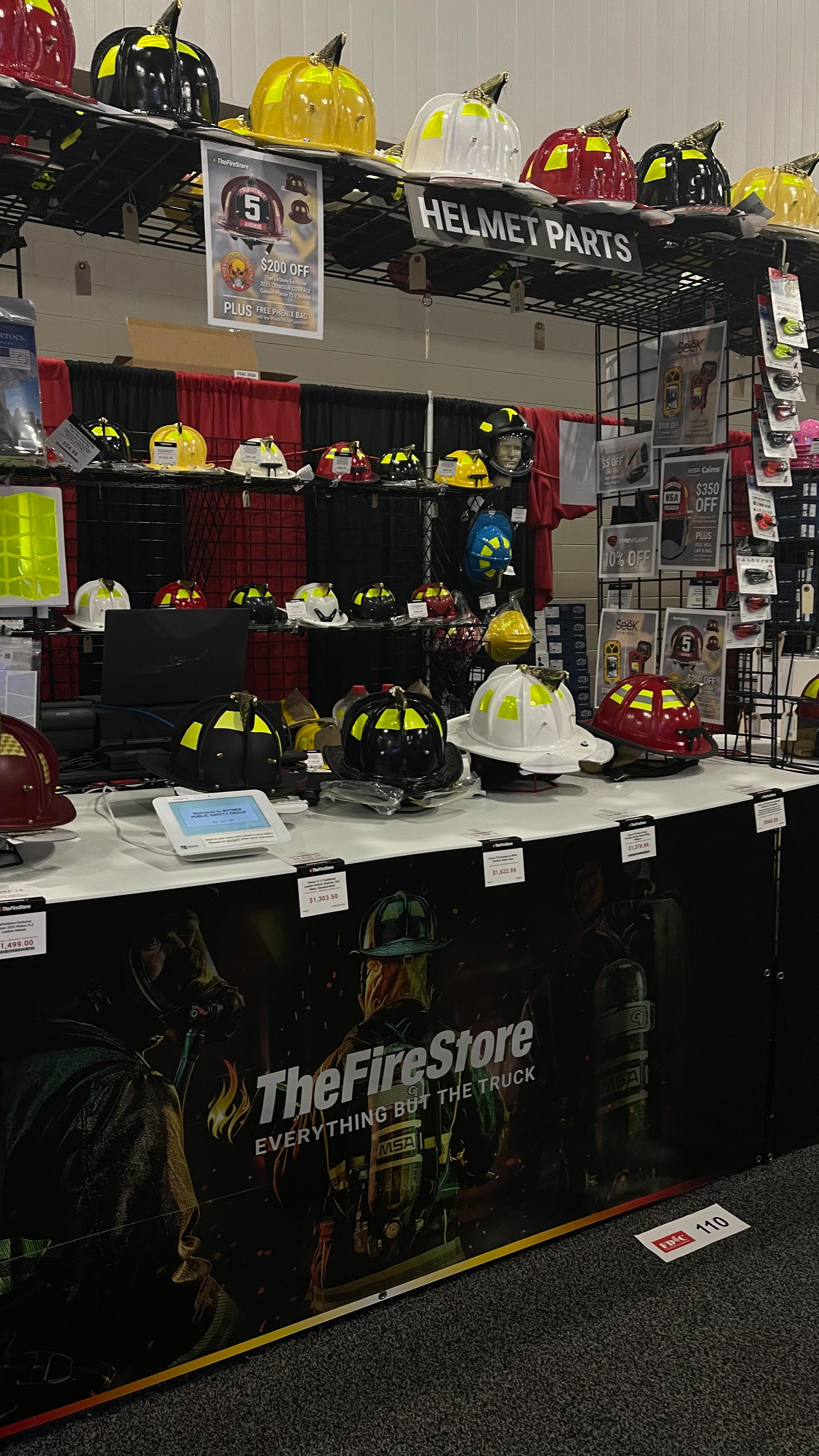 Display of various fire helmets at a trade show booth.
