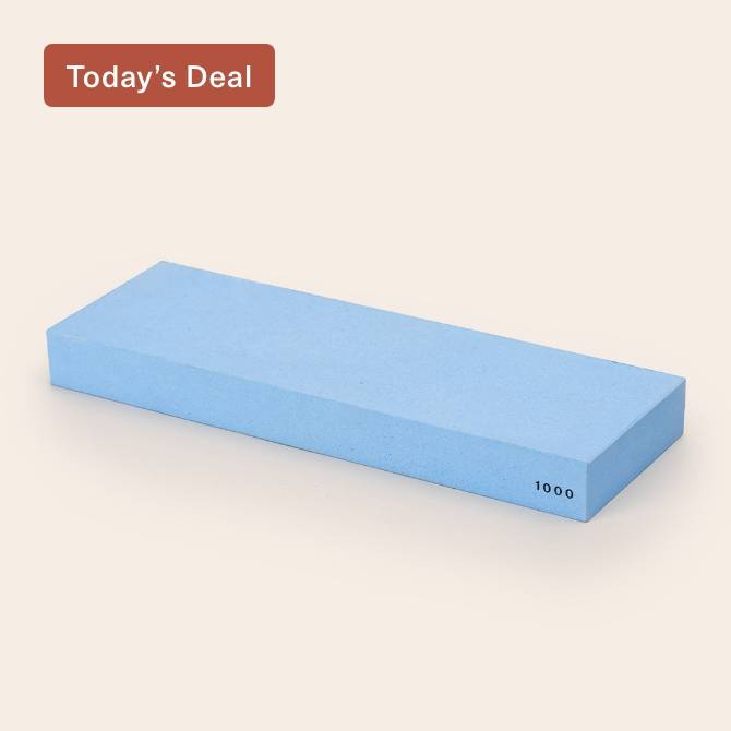 A blue Misen 1000-grit Sharpening Stone, seen from an angle with the number 1000 visible along the edge.
