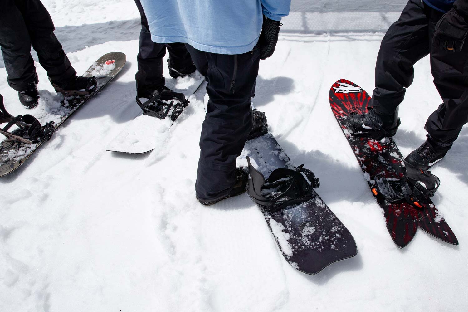 People standing on snowboards in a snowy landscape.