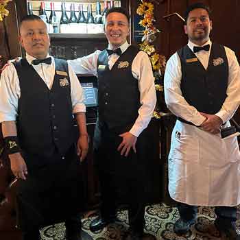 Waiters wearing black bow ties and vests