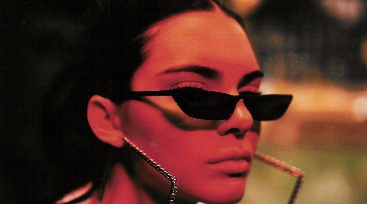 Le mannequin Kendall Jenner porte des lunettes de soleil œil-de-chat à moitié coupées des années 90.