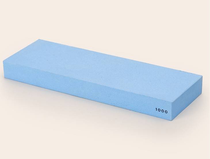 A blue Misen 1000-grit Sharpening Stone, seen from an angle with the number 1000 visible along the edge.