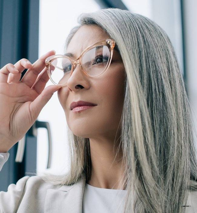 Woman with grey hair wearing cat eye glasses