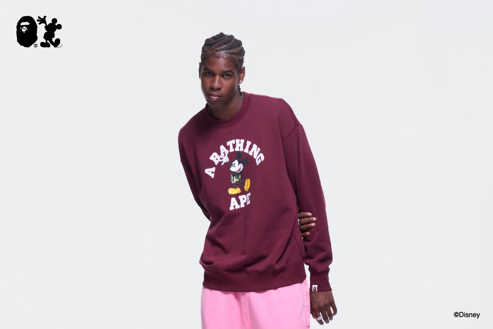 Person wearing a maroon sweatshirt with a graphic design and pink shorts.