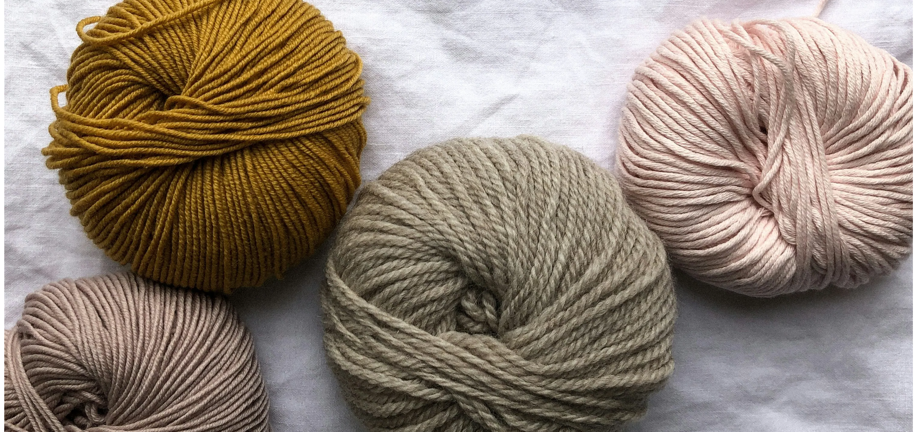 4 balls of wool in pastel colours