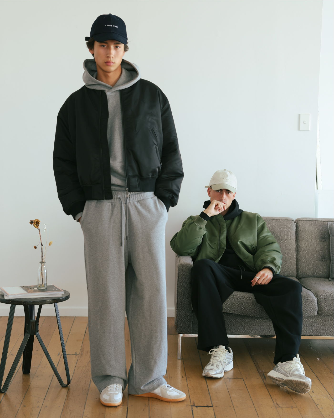 Two young men in casual outfits posing indoors.