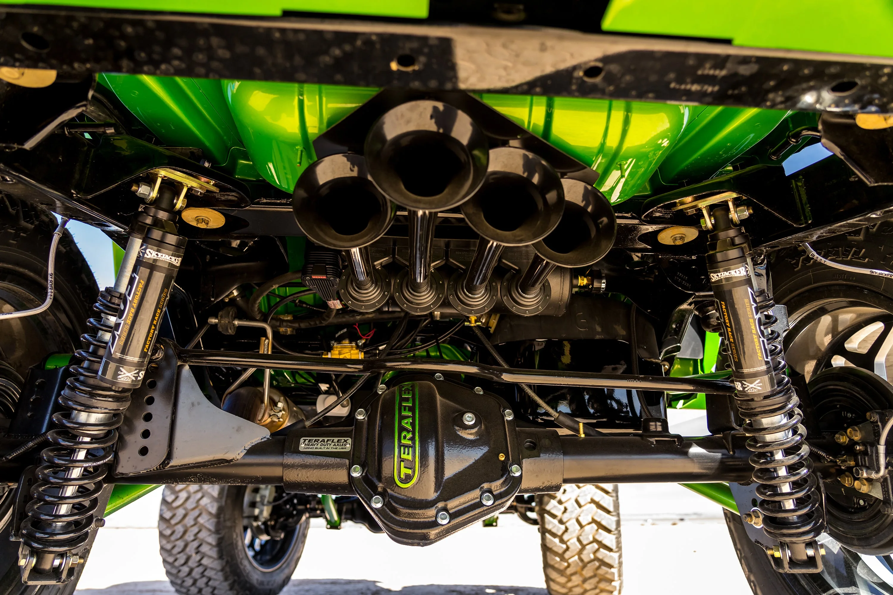 Spare tire delete bay underside Cambered Customs Jeep Wrangler JK four black Conductor's Special 244 Nightmare Edition train horn bells cylindrical air tank blue airlines pressure gauge rear axle tires photo 3
