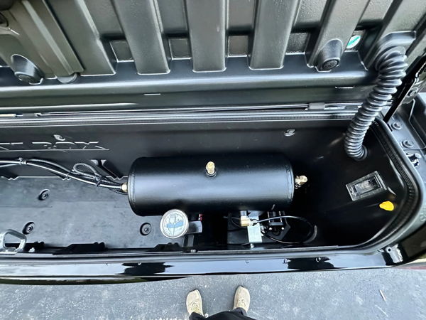 Top-down view of HornBlasters air tank and compressor installed inside black storage compartment