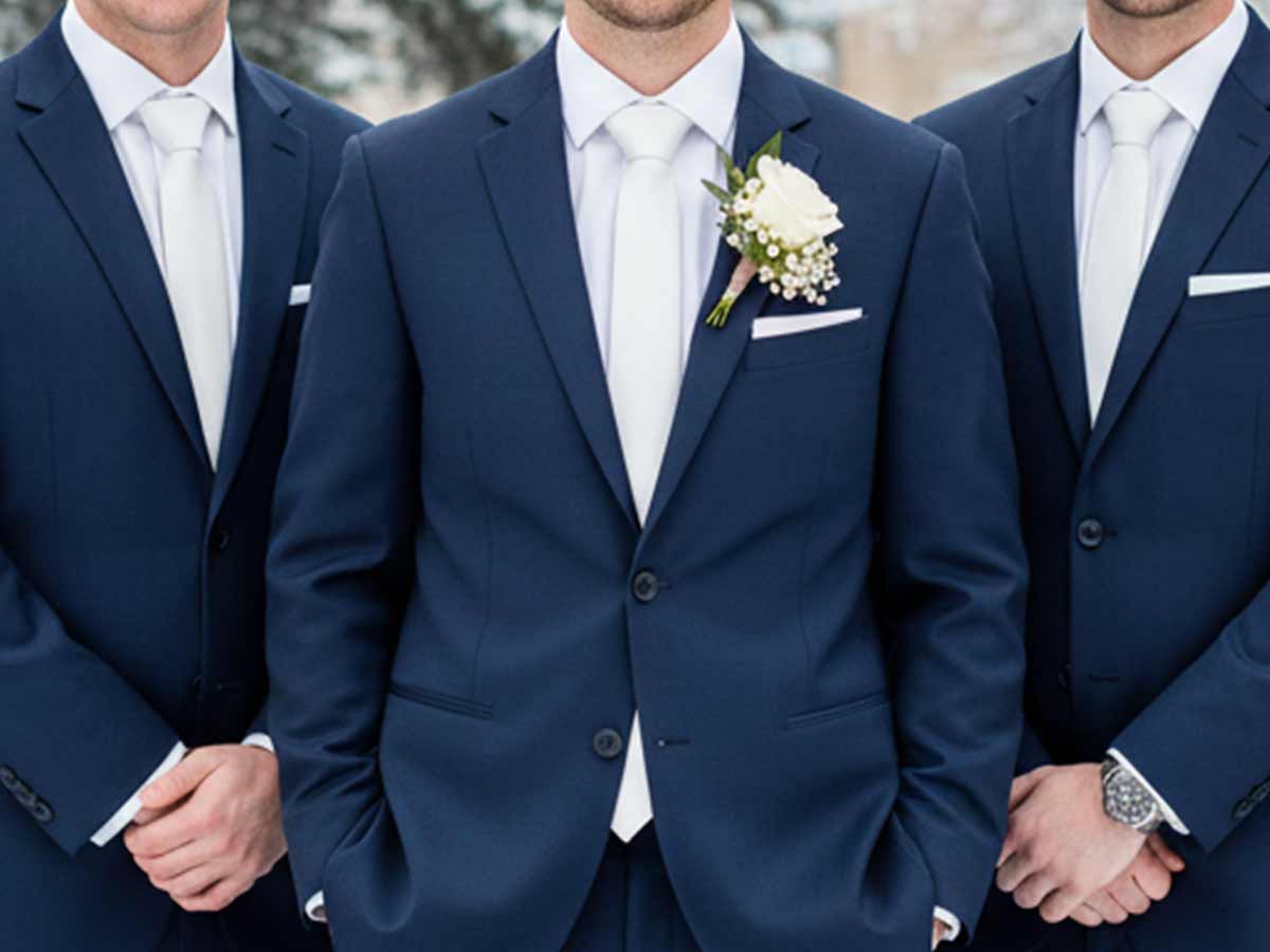 Groom and his groomsmen with white ties with navy blue suits for a crips, clean wedding look