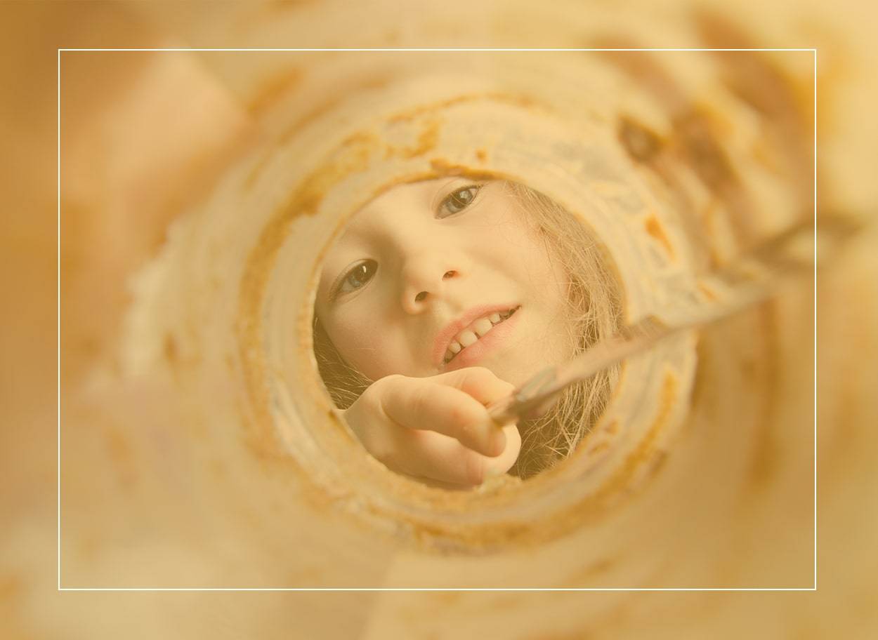 Un enfant utilise un couteau pour racler un pot de beurre d’arachide presque vide - une friandise interdite s’il présente des symptômes d’allergie aux arachides.