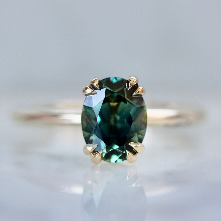 Green-blue oval cut sapphire ring with double claw prongs