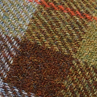 Brown, olive green and cream Harris Tweed fabric with multicoloured woven texture.