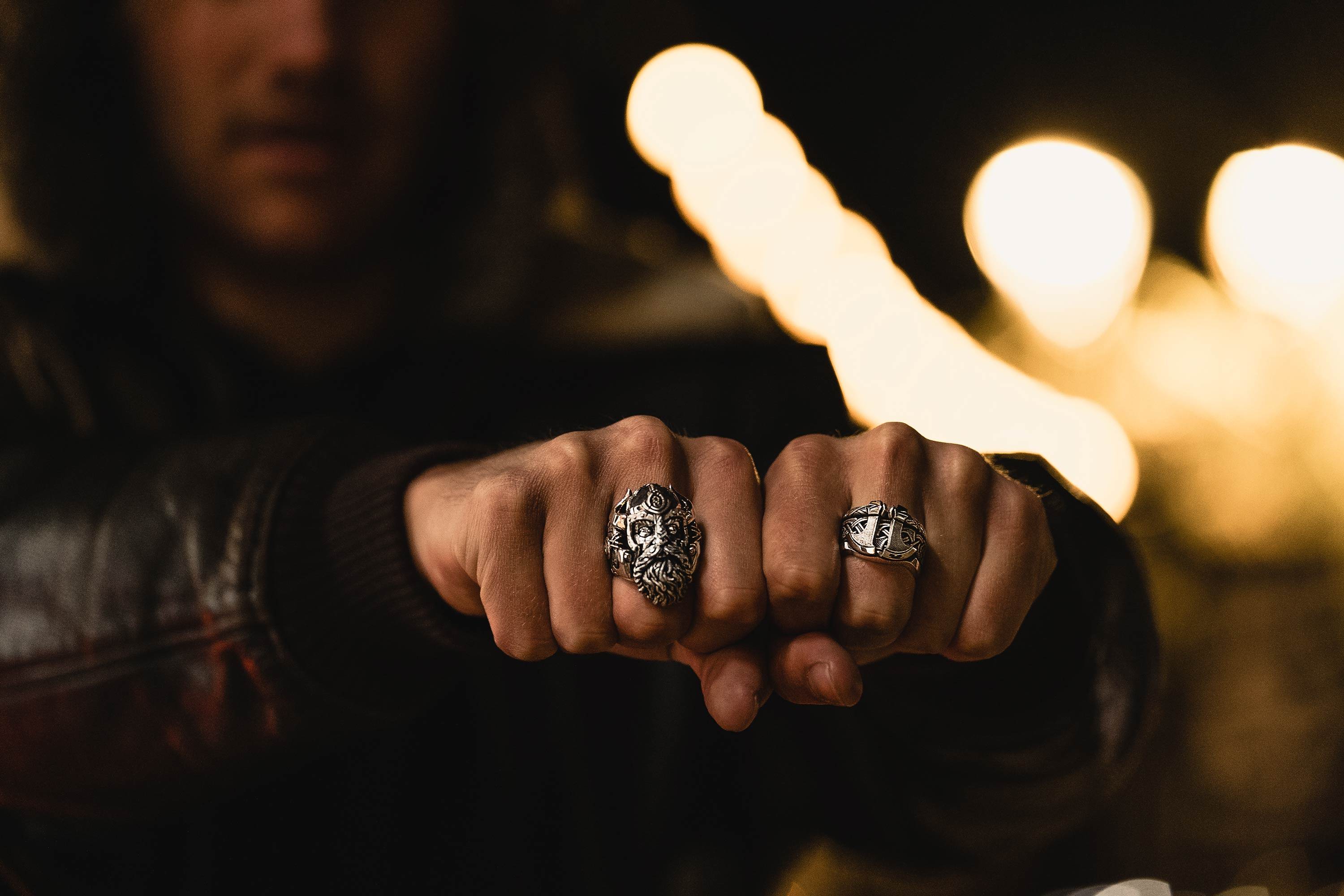 A man holds out both fists, wearing Einherjar Ring and Einherjar Band