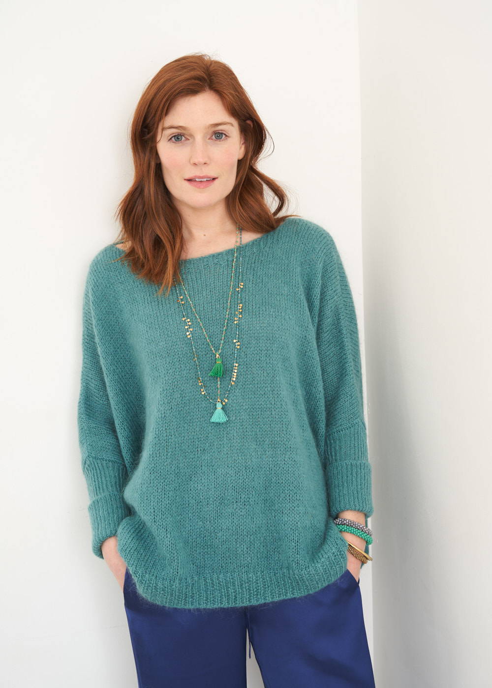A model wearing a teal green knitted slouchy sweater