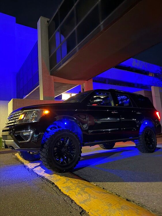 Nighttime low-angle view Troy's lifted 2018 Ford Expedition with blue LED rock lights under chassis gallery photo 17