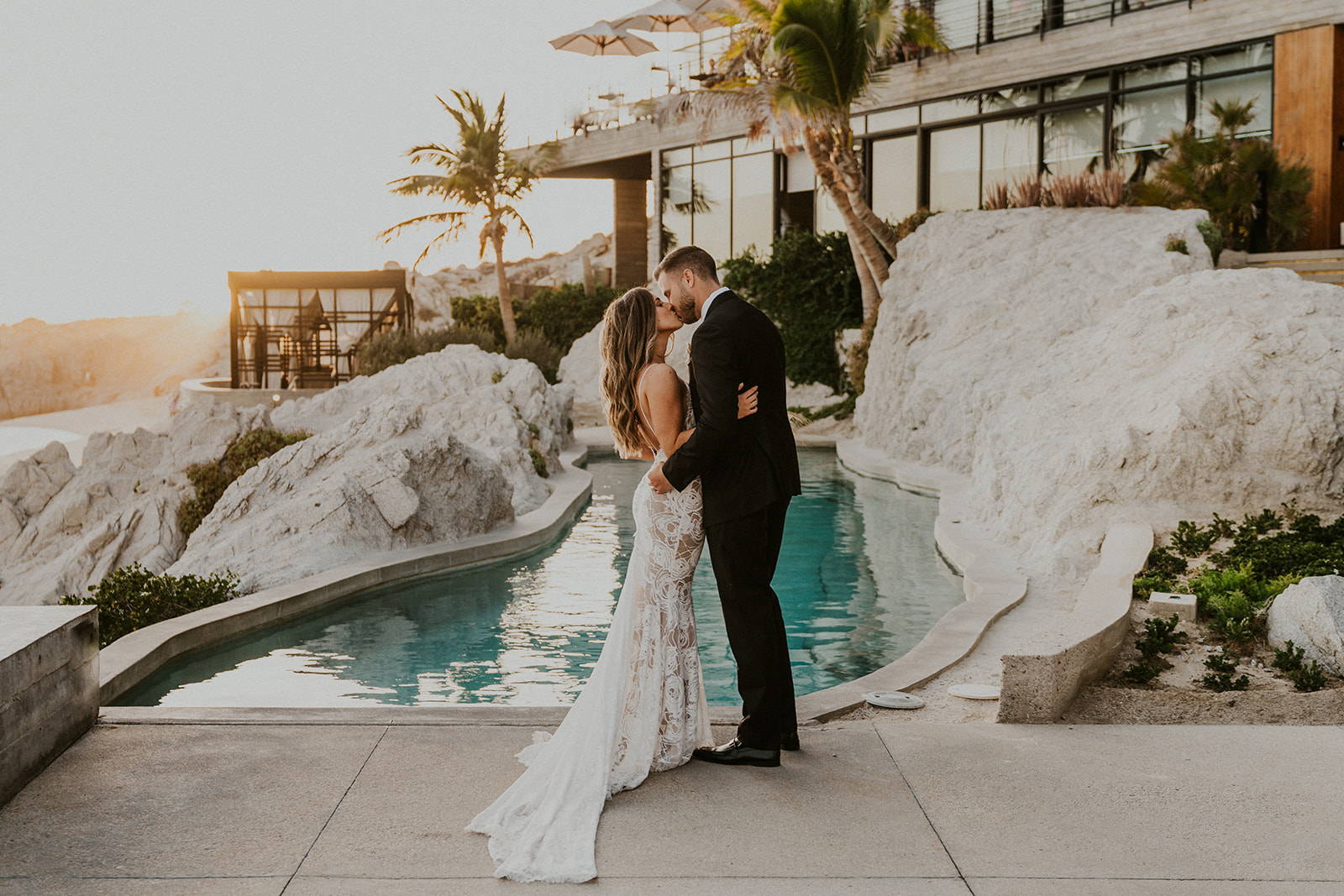 Grace Laces Lace bride kissing in front of pool in Mexicol