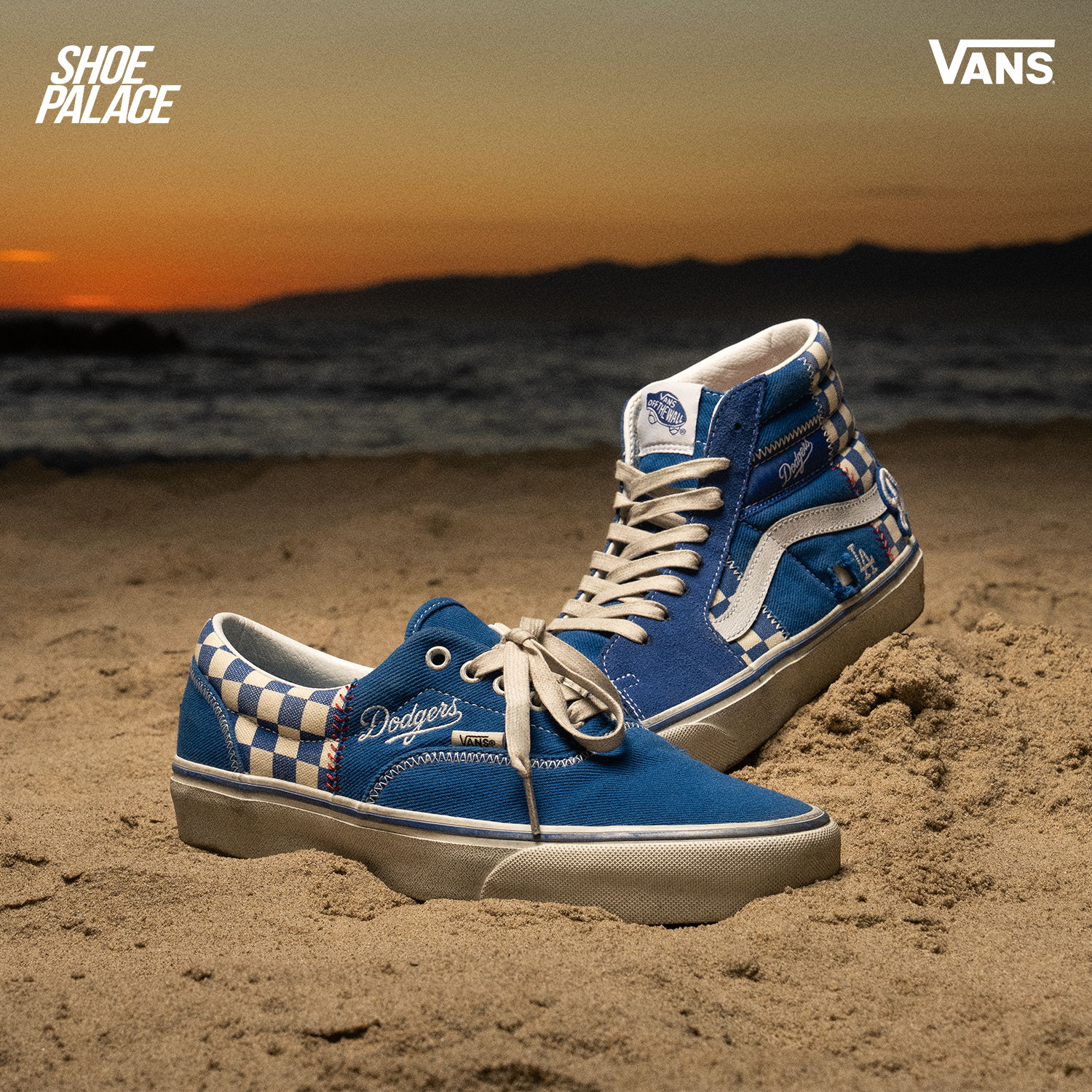 Blue Vans shoes on the sand with a sunset background.