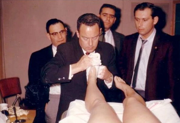 Merton L. Root demonstrating a casting technique while colleagues watch