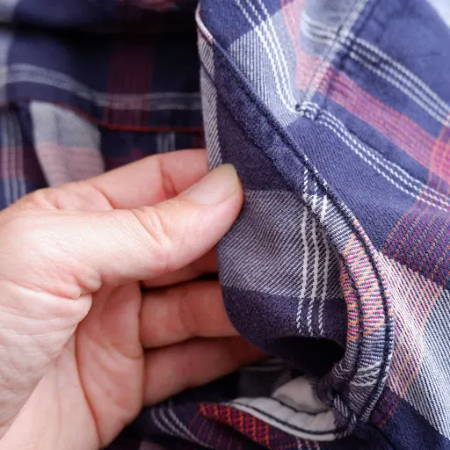 A flat felled seam on the armscye of a flannel shirt, the seam on the inside