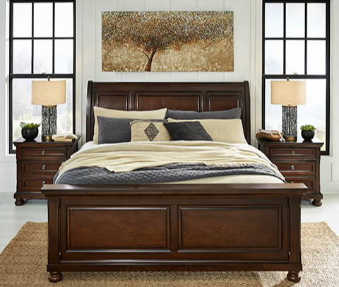 A cozy bedroom with a wooden bed, nightstands, and artwork on the wall.