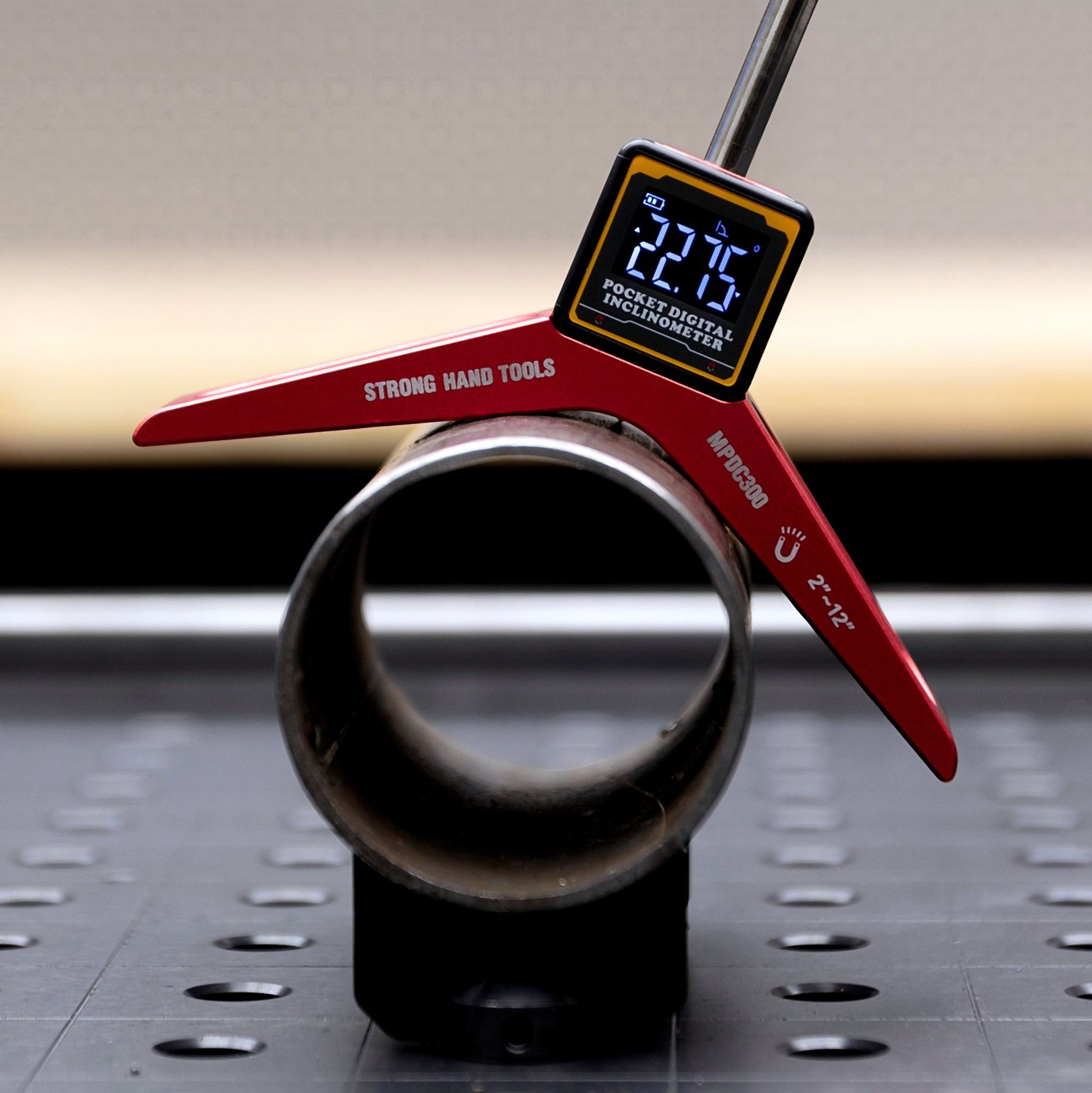 Digital caliper measuring the diameter of a metal pipe.