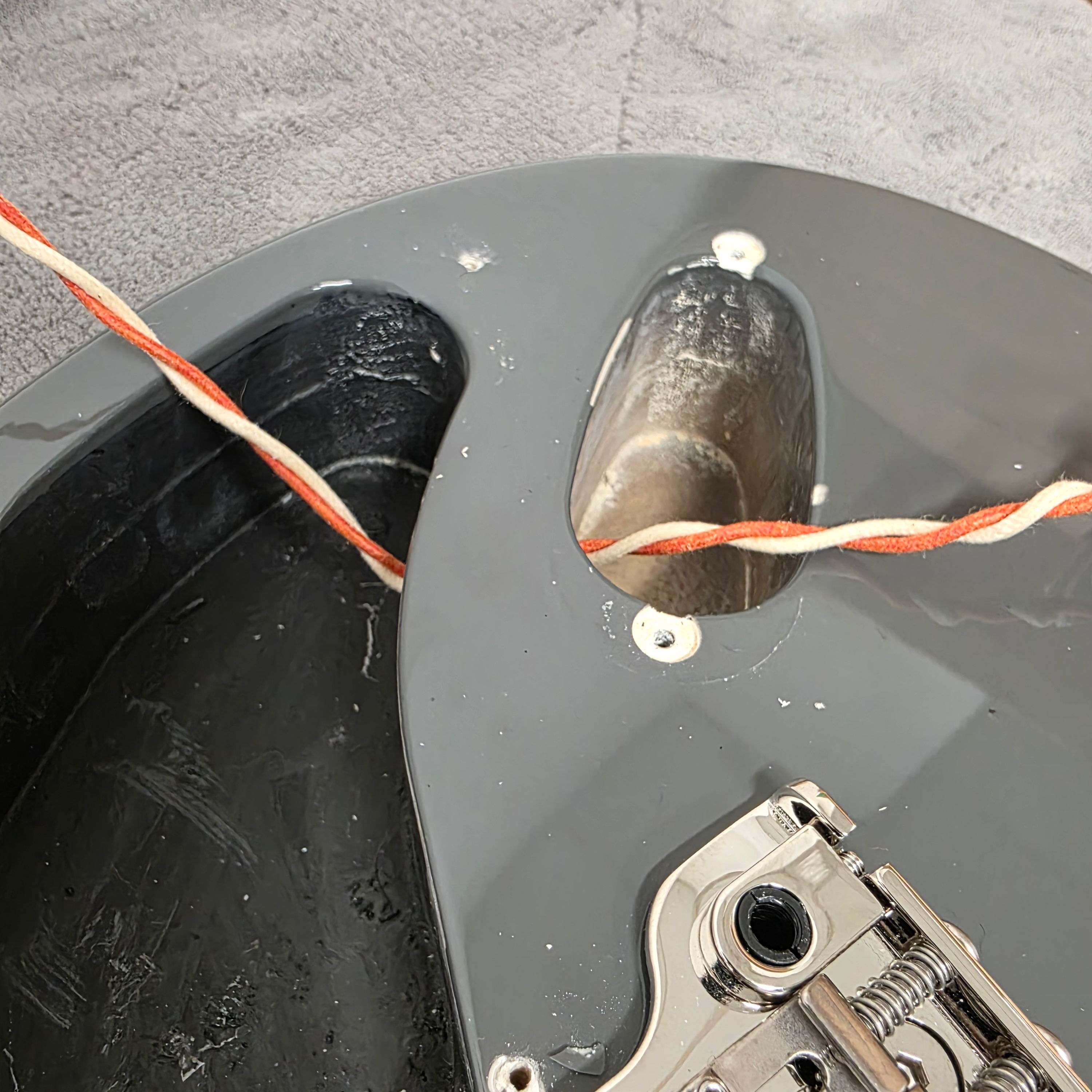 Close-up of the interior of a guitar body with wires and components visible.