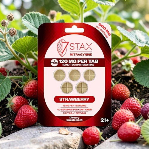 Strawberry-flavored tablet packaging among fresh strawberries in a garden setting.
