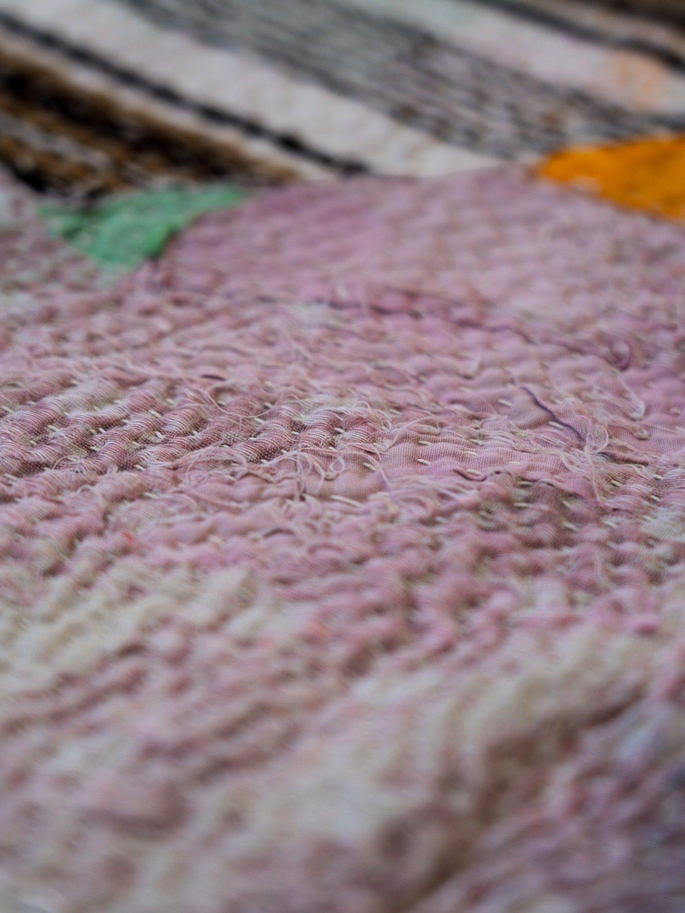 Textured fabric with soft pastel colors and intricate patterns.
