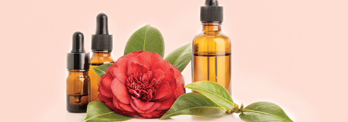Amber bottles and a red flower on a pink background.