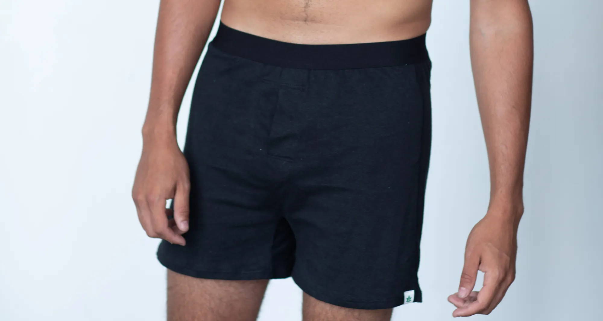 man wearing black boxers against a white background 