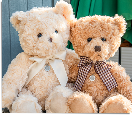 two brown memorial teddy bears wearing a fingerprint necklace