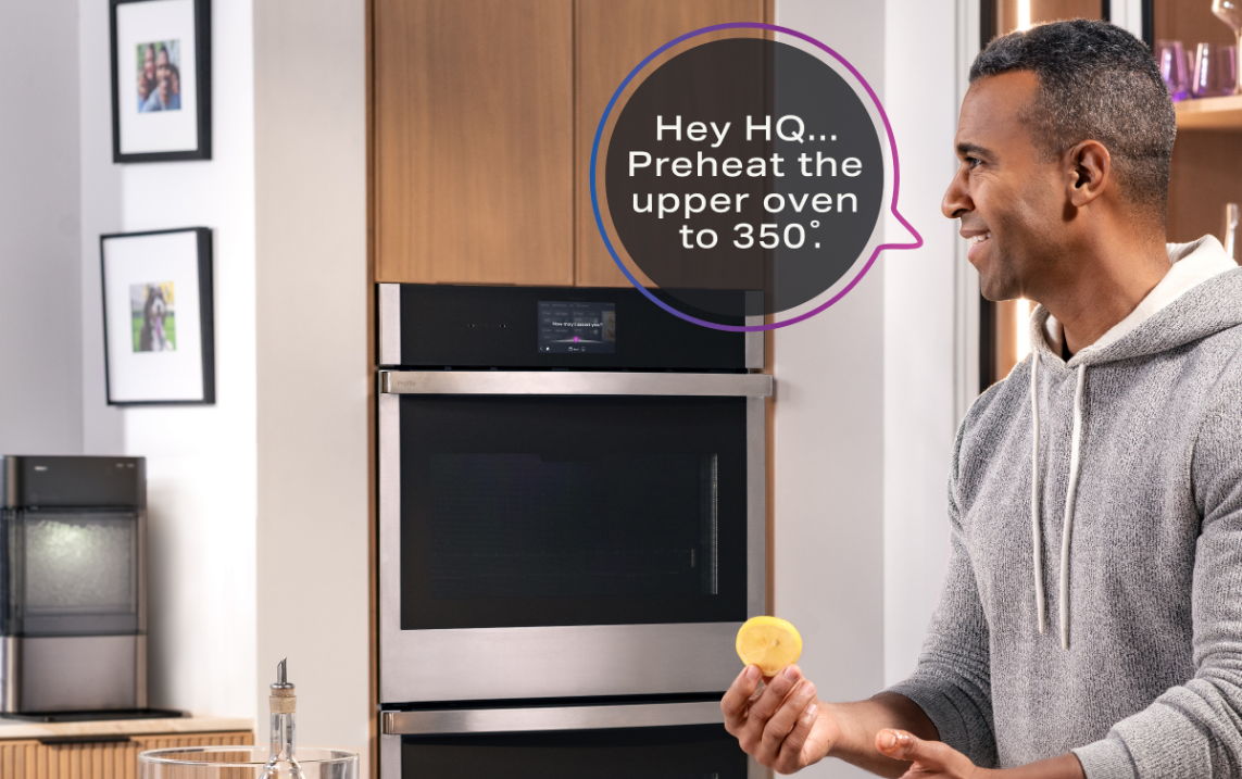 Man in kitchen using smart oven with a voice command.
