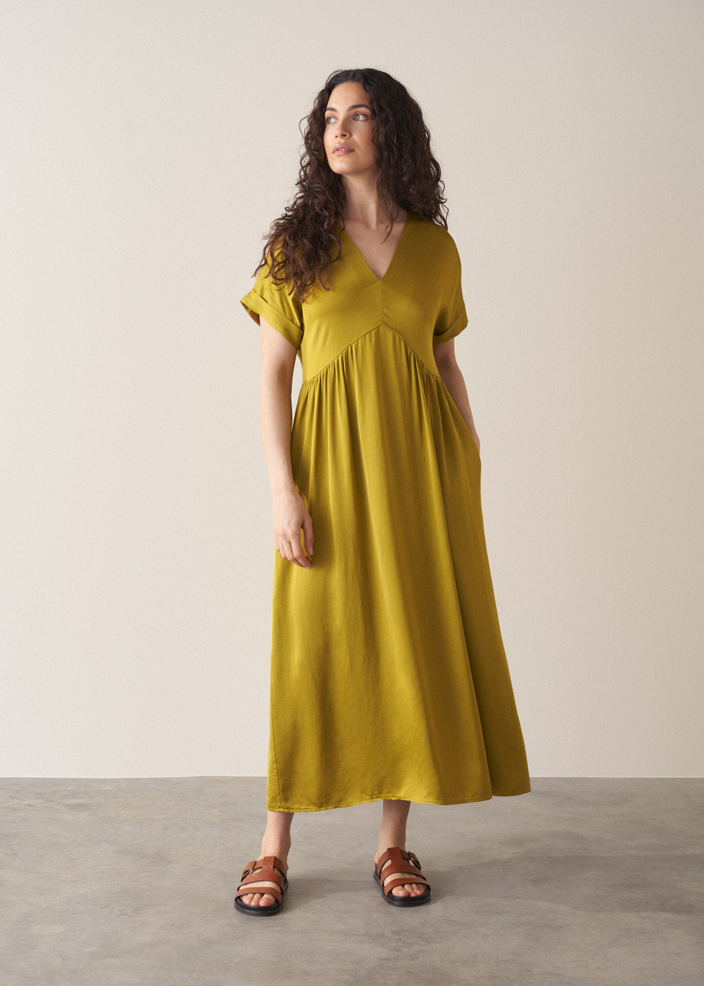 Woman wearing chartreuse yellow satin midi dress