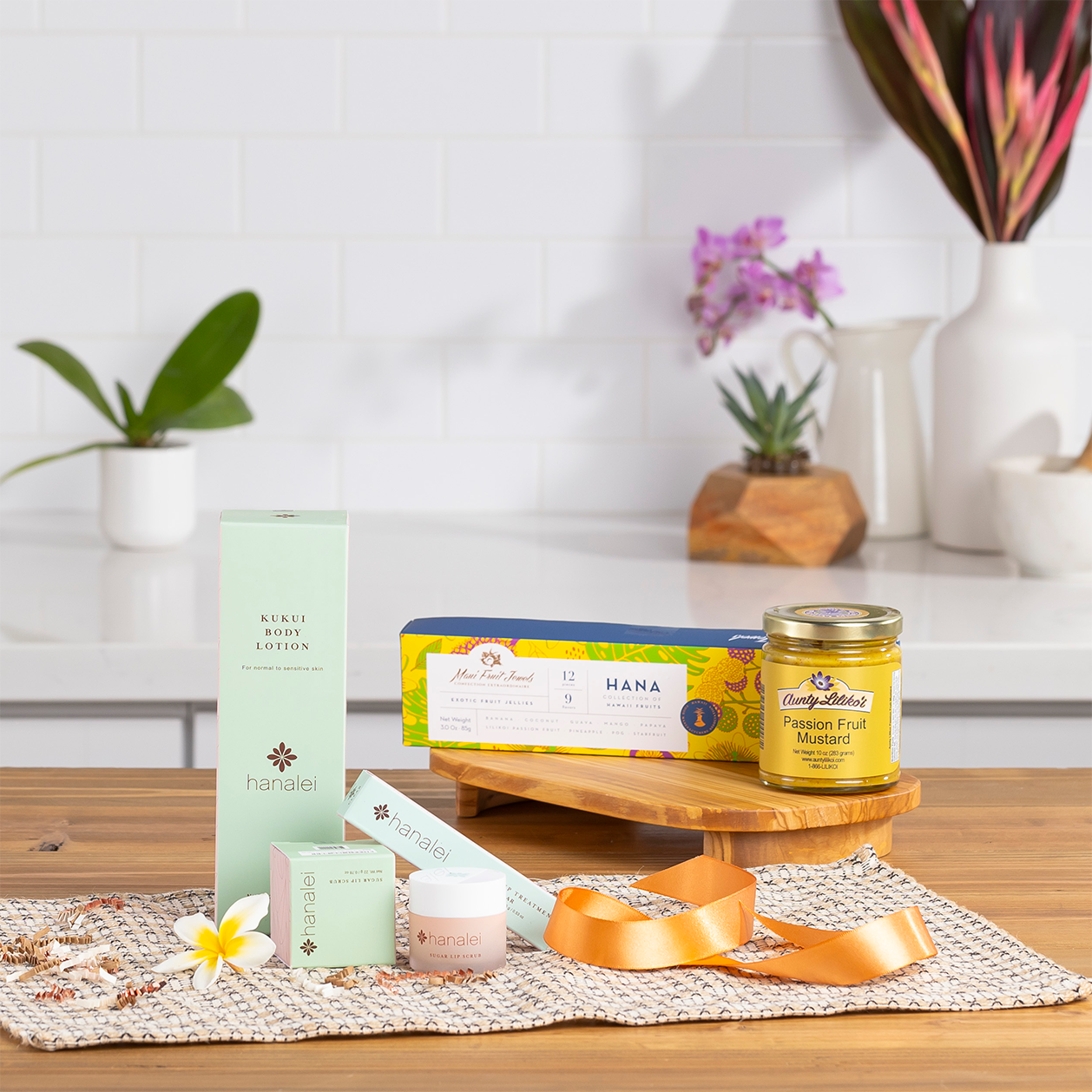 Skincare products and a candle arranged on a wooden table with plants.