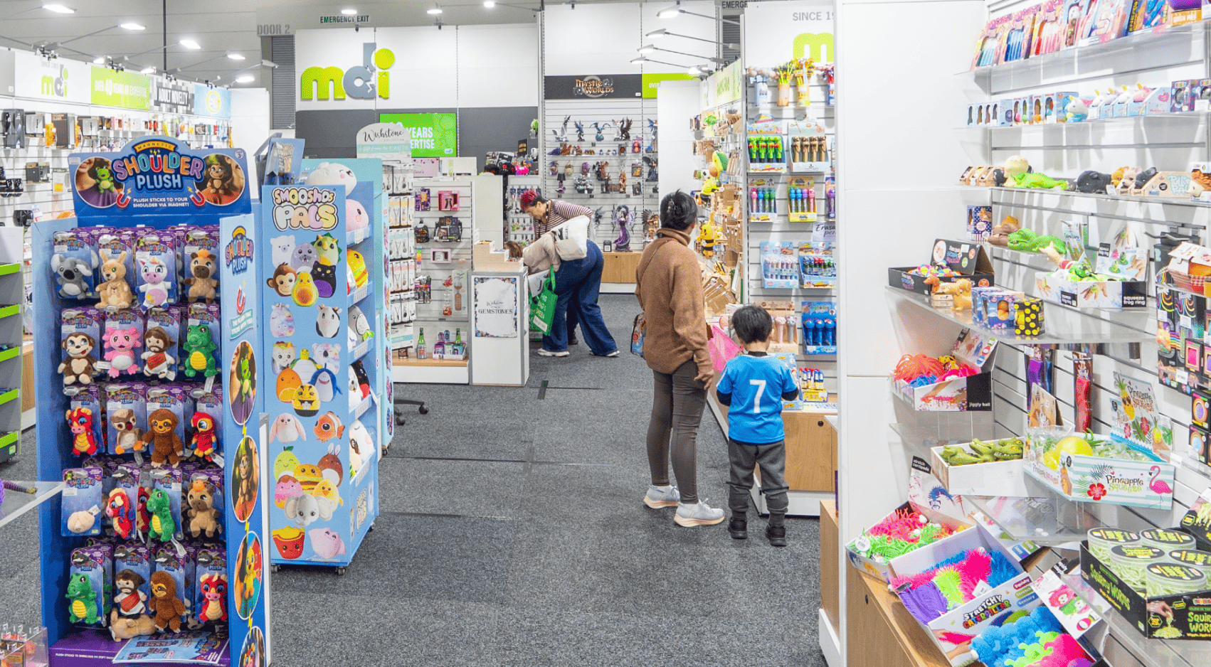 A colorful store aisle filled with toys and stationery.