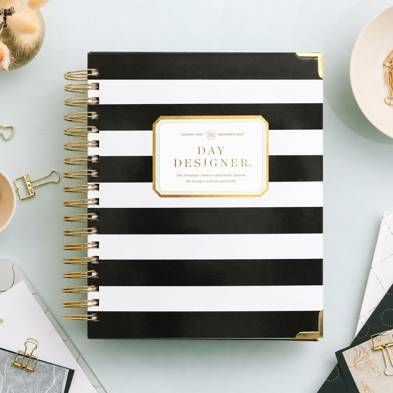 2027 day designer planner with black and white cover, gold binding, light mint background