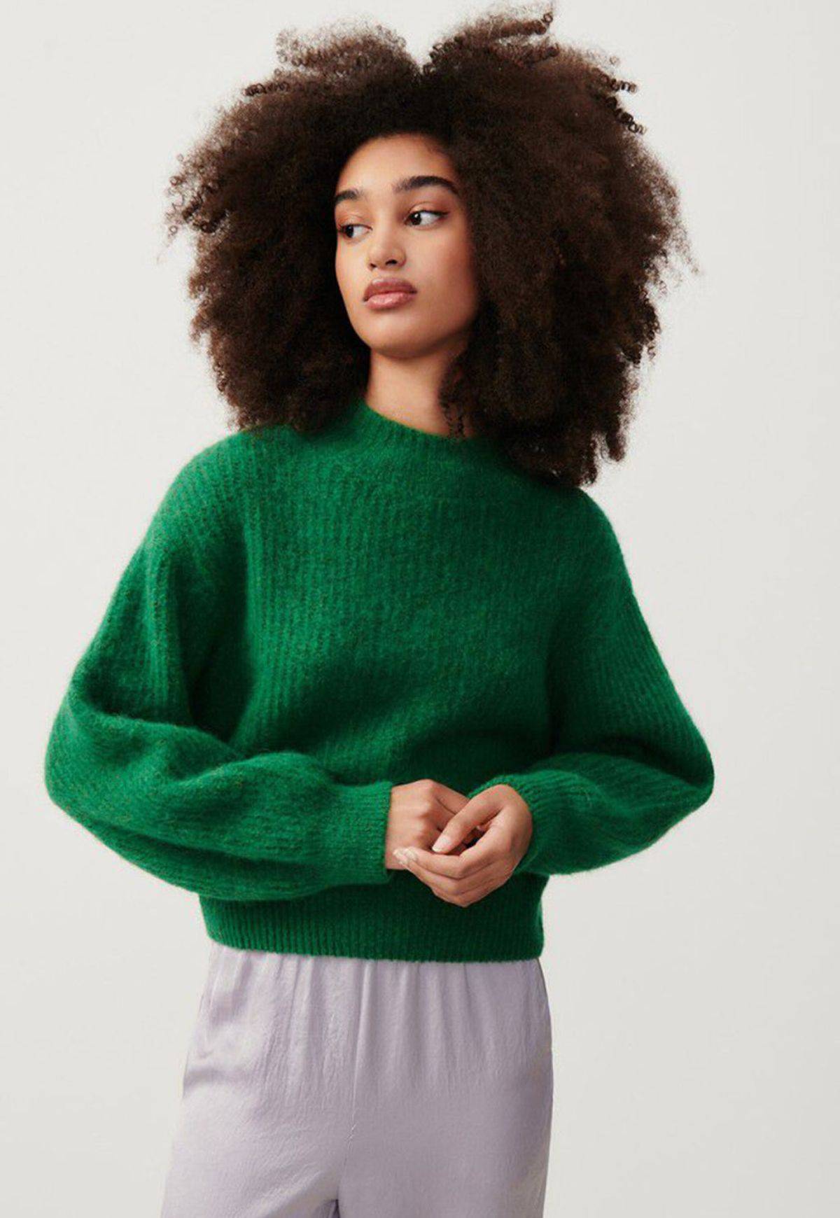 Image of a woman wearing East Sweater by American Vintage in Pelouse Chine, a forest green colour. it has a high collar and ribbed detailing and long sleeves.