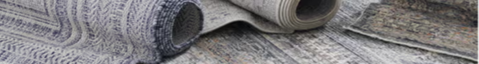 Rolled fabrics with various patterns and textures on a flat surface.