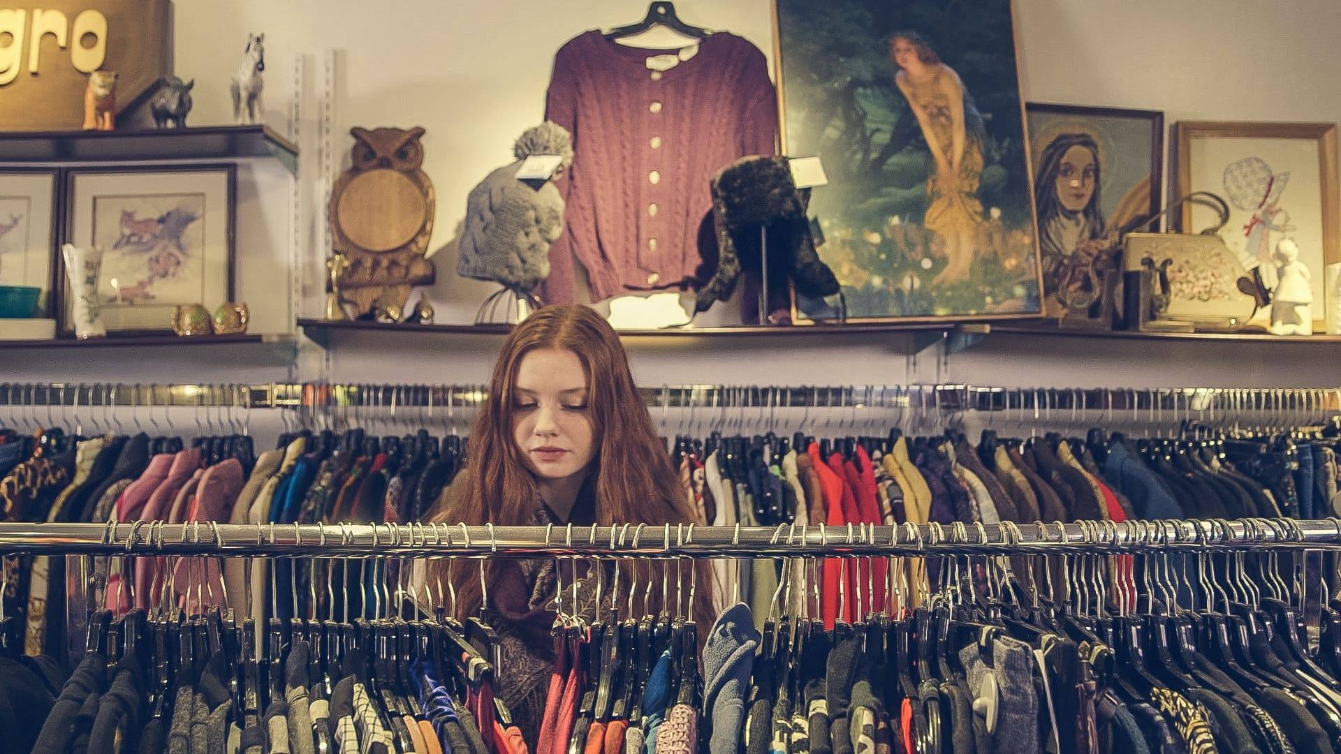 woman looking through racks of vintage clothes