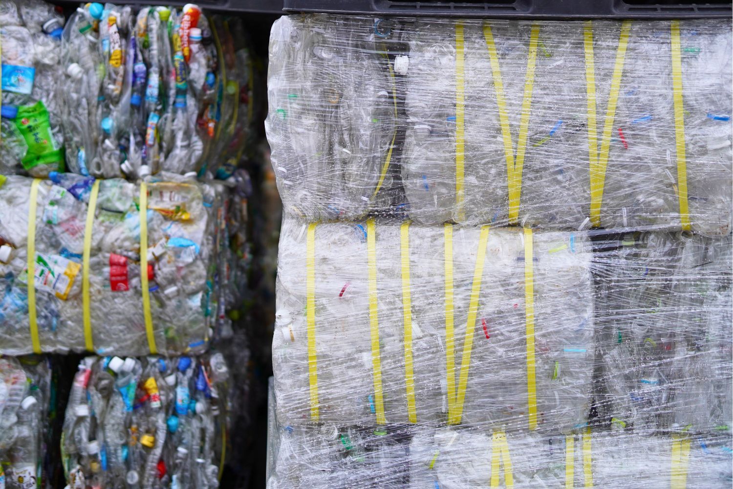 Baled plastic waste wrapped in yellow straps.