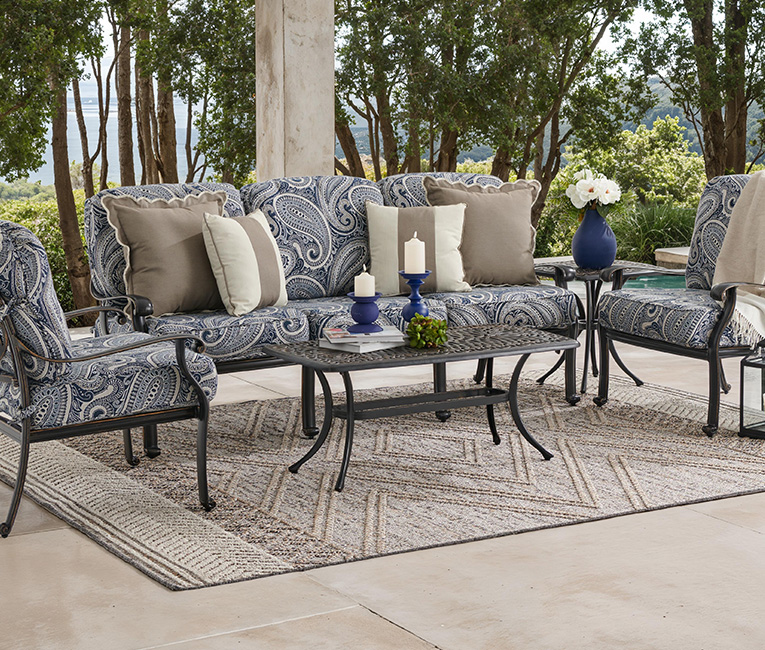 Outdoor seating area with patterned cushions and a coffee table.