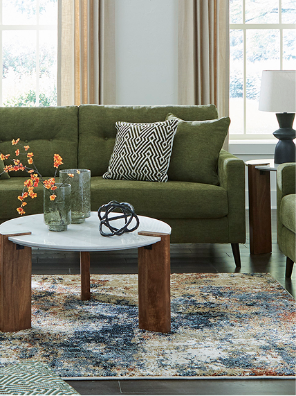 Green sofa and natural textures styled with seasonal decor and wood furnishings.