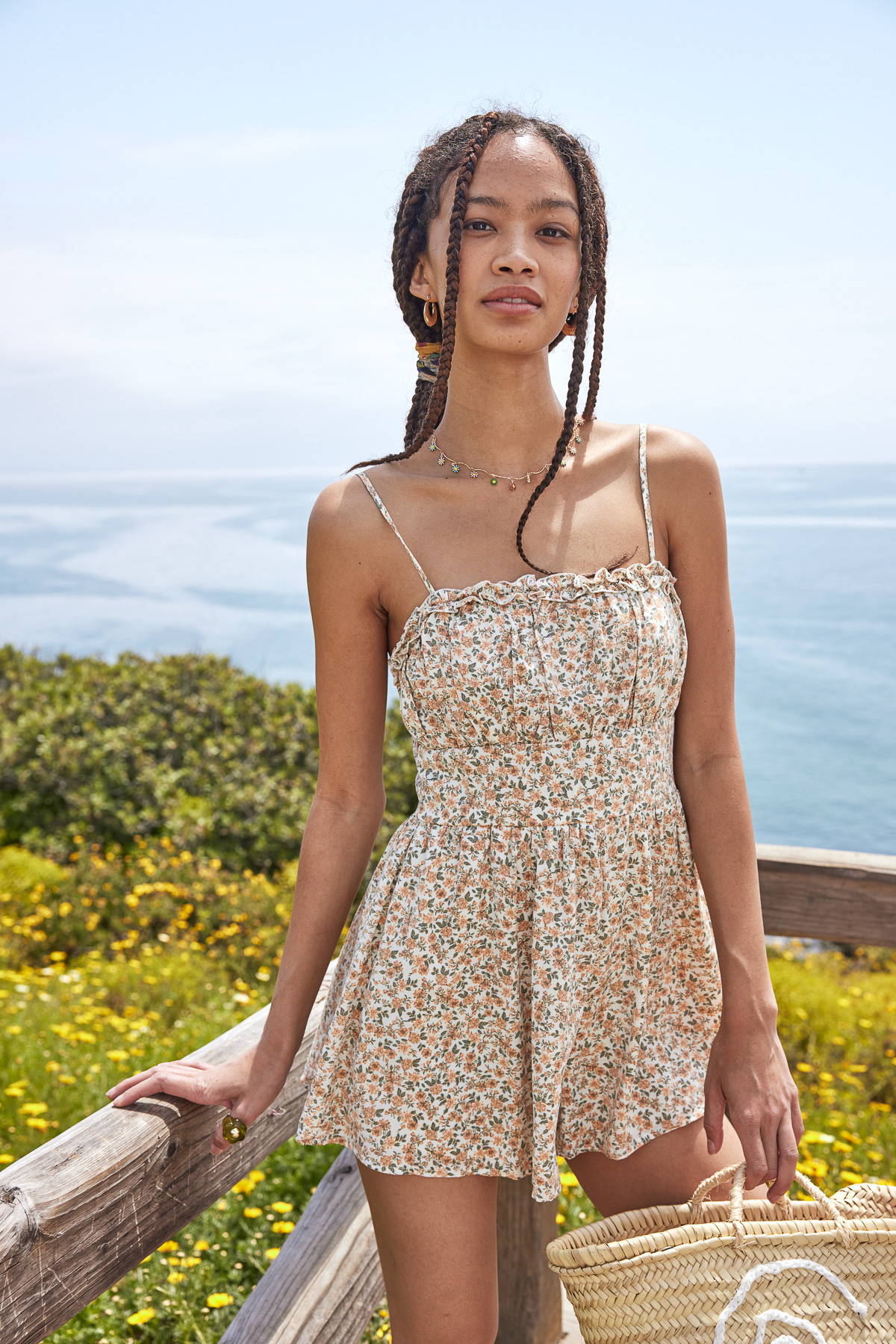 Trixxi sun-kissed summer, girl at ocean side beach pier, in yellow floral ditsy romper.