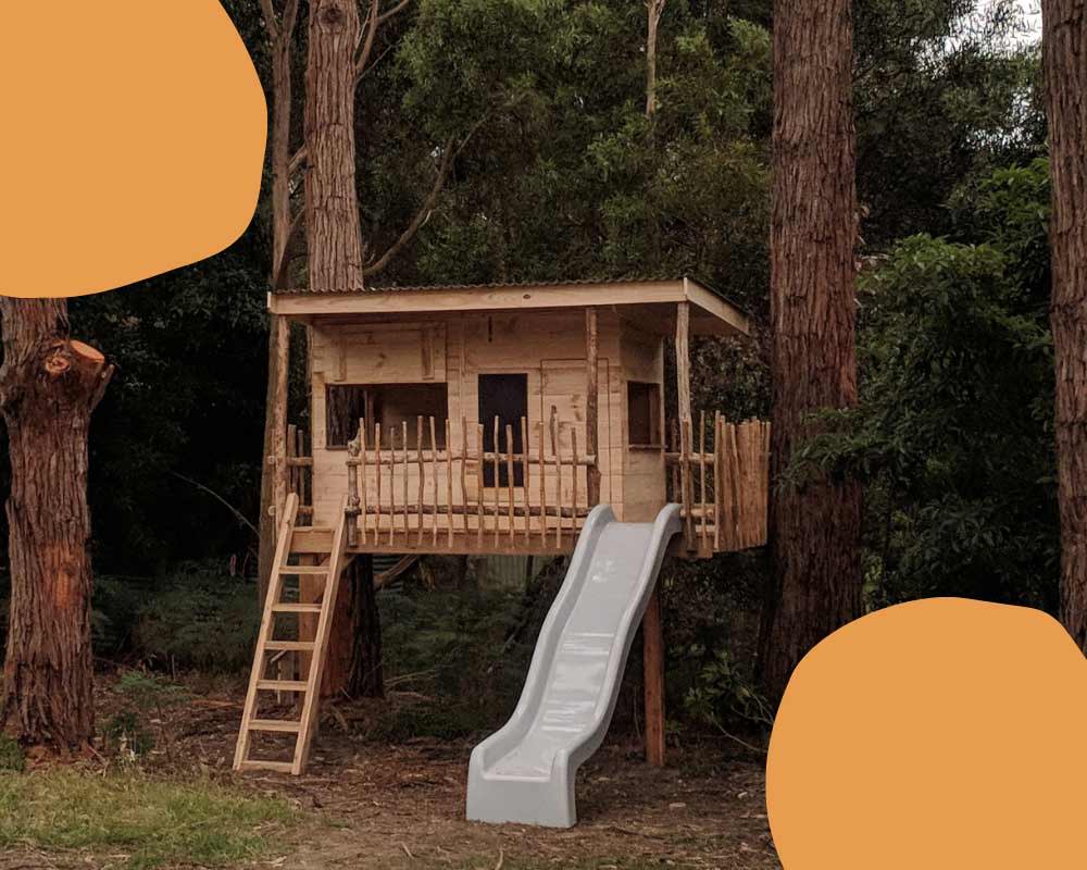 A Wooden Treehouse Cubby House with slide